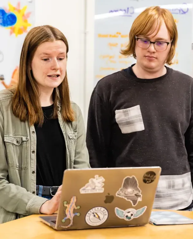 Two students review health law on a laptop